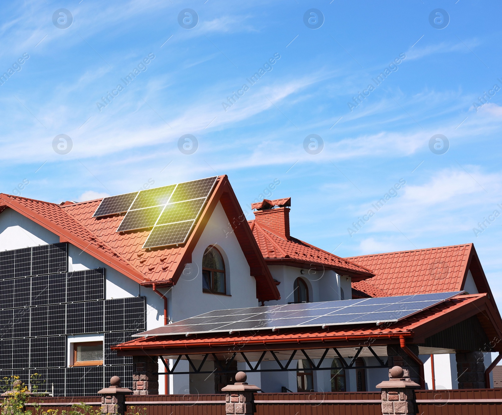 Photo of House with installed solar panels under blue sky. Alternative energy source