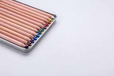Colorful pastel pencils in box on white background, space for text. Drawing supplies