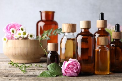 Aromatherapy. Different essential oils and flowers on wooden table