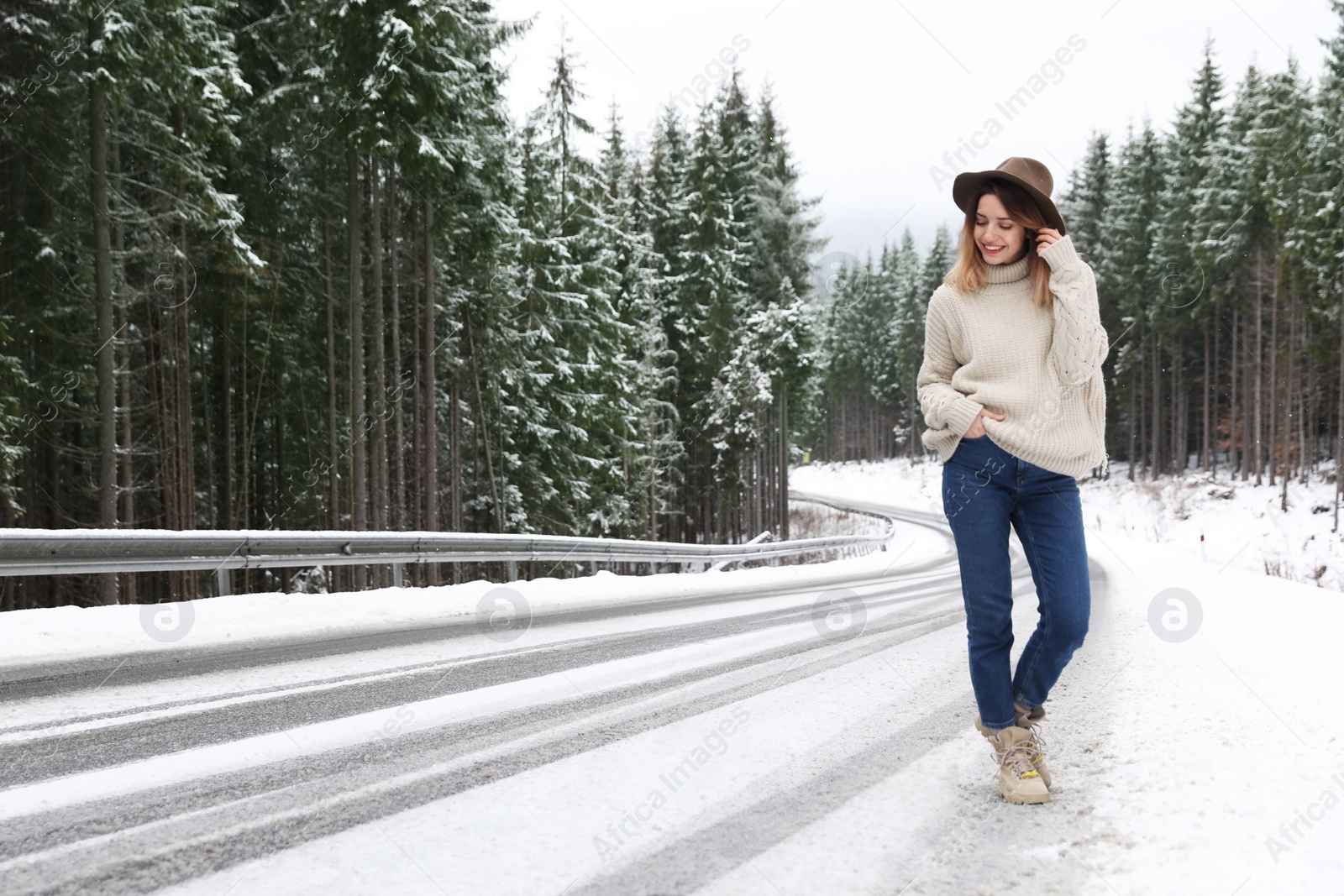 Photo of Young woman walking near snowy forest. Winter vacation