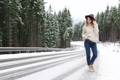 Photo of Young woman walking near snowy forest. Winter vacation