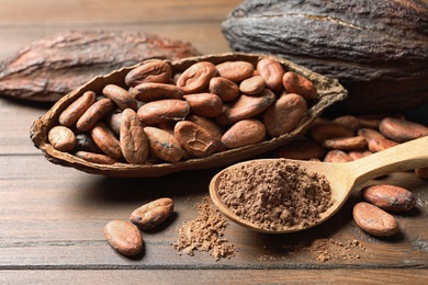 Photo of Composition with cocoa pods, beans and powder on wooden table