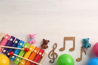 Baby song concept. Wooden notes, xylophone and toys on table, flat lay. Space for text