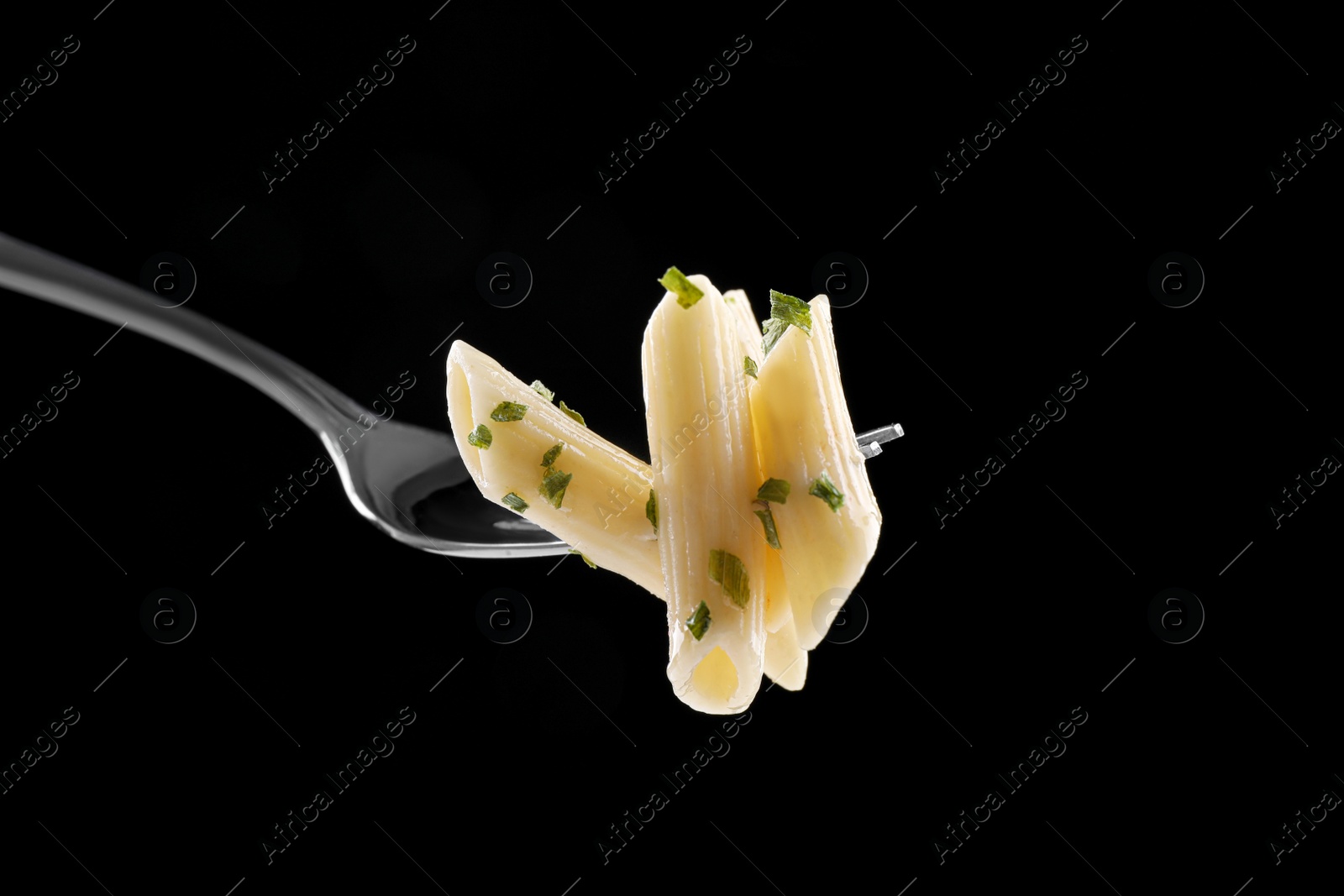 Photo of Fork with delicious penne pasta on black background