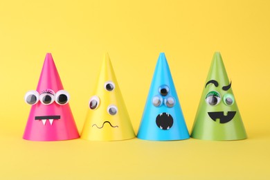 Photo of Spooky paper monsters on yellow background. Halloween decoration