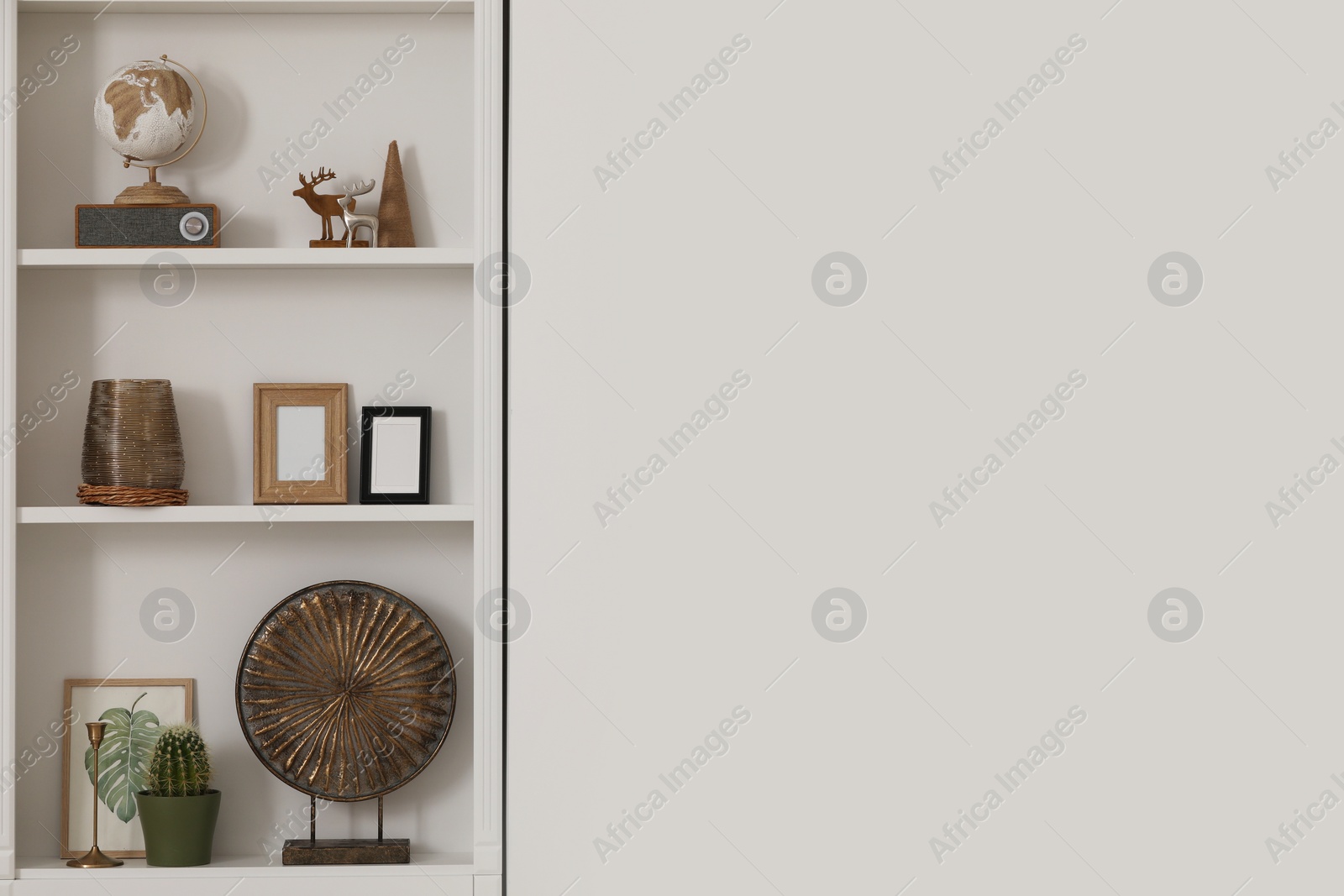 Photo of Stylish shelves with different decor elements indoors, space for text. Interior design