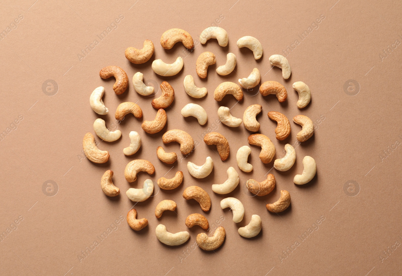 Photo of Tasty cashew nuts on color background, flat lay