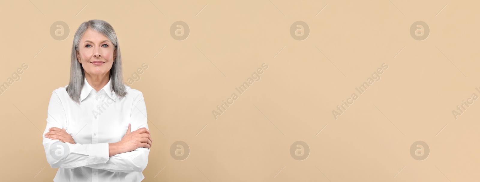 Image of Portrait of beautiful mature woman on beige background. Banner design with space for text