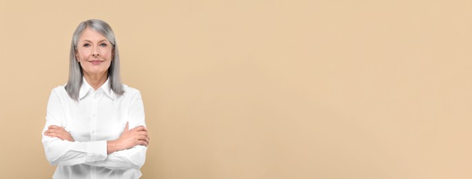 Portrait of beautiful mature woman on beige background. Banner design with space for text