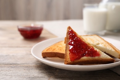 Tasty toasts with jam served for breakfast on wooden table