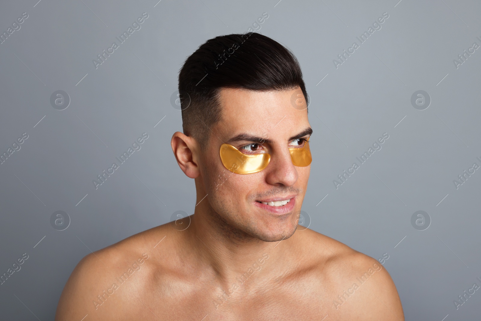 Photo of Man with golden under eye patches on grey background