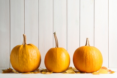 Photo of Ripe pumpkins on table against wooden background. Holiday decoration