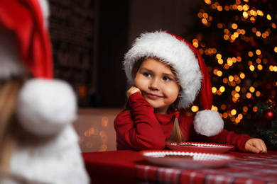 Photo of Cute little children at table in dining room. Christmas time