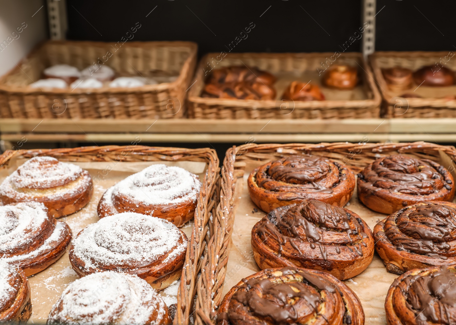 Photo of Wicker trays with different sweet buns in bakery