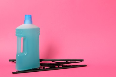 Photo of Bottle of windshield washer fluid and wipers on pink background. Space for text