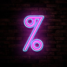 Image of Glowing neon percent sign on brick wall