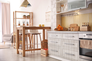 Photo of Modern kitchen interior with stylish wooden table