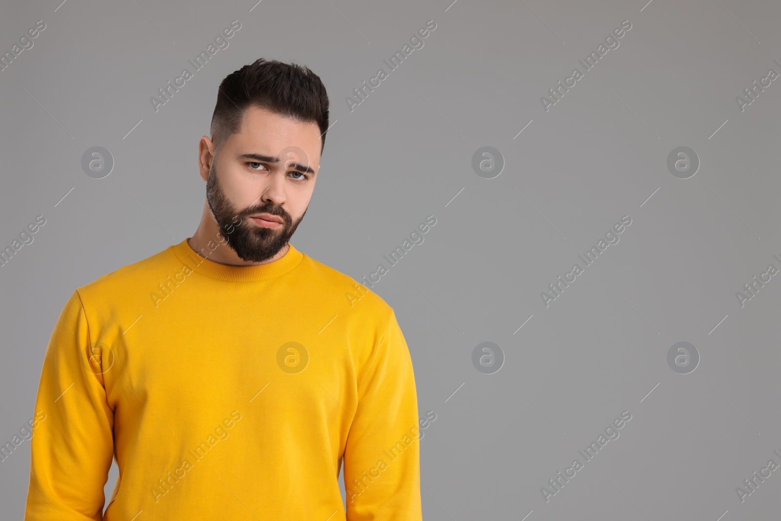 Photo of Portrait of sad man on light grey background, space for text