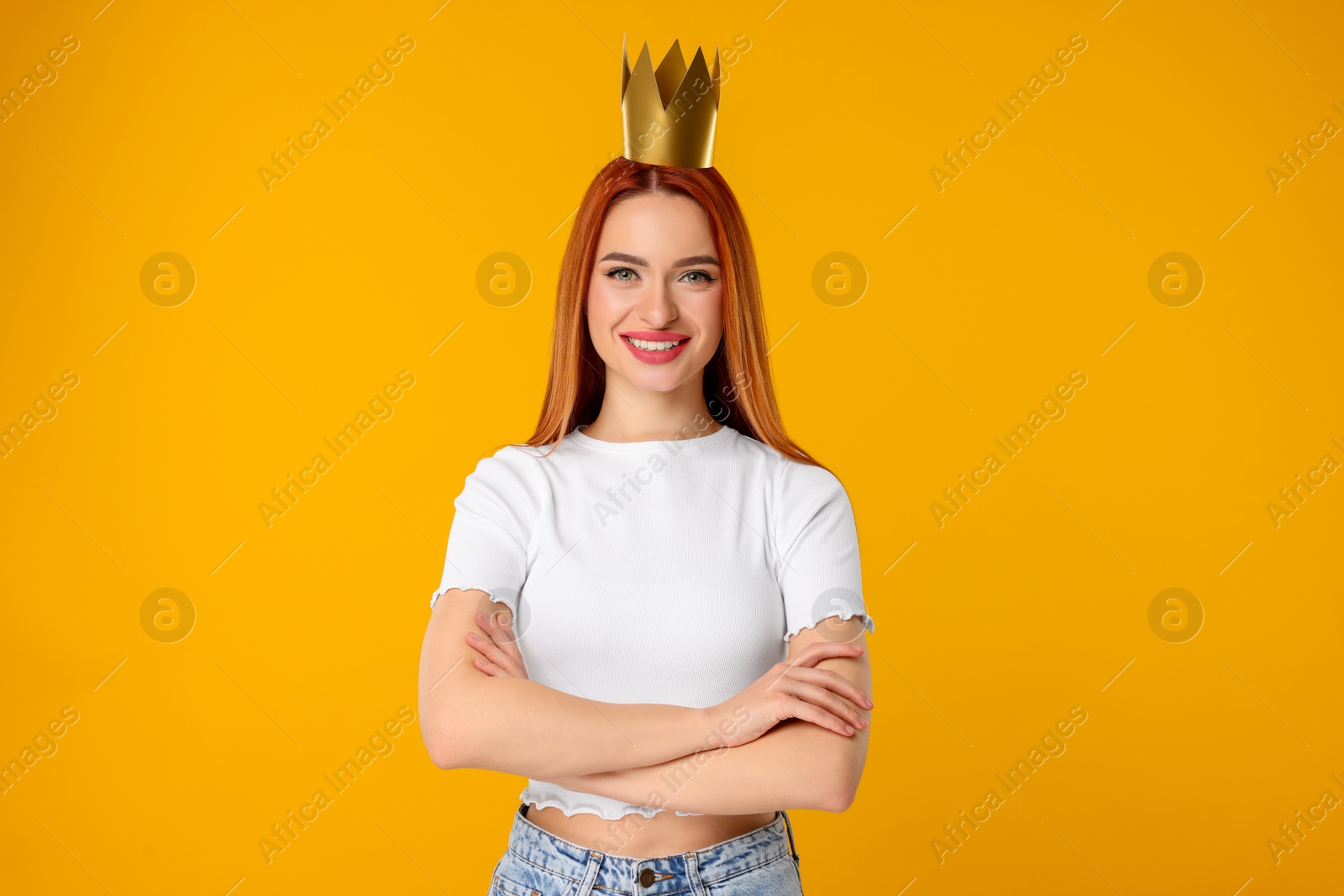 Photo of Beautiful young woman with princess crown on orange background