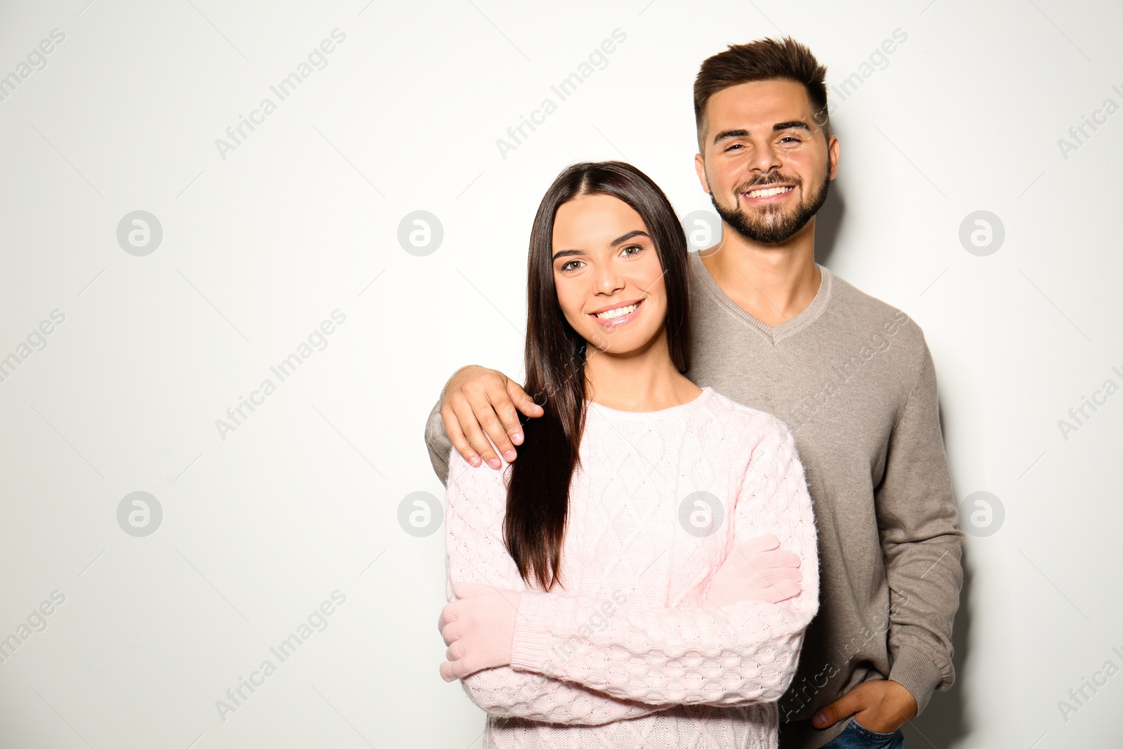 Image of Lovely couple in warm sweaters on light background 