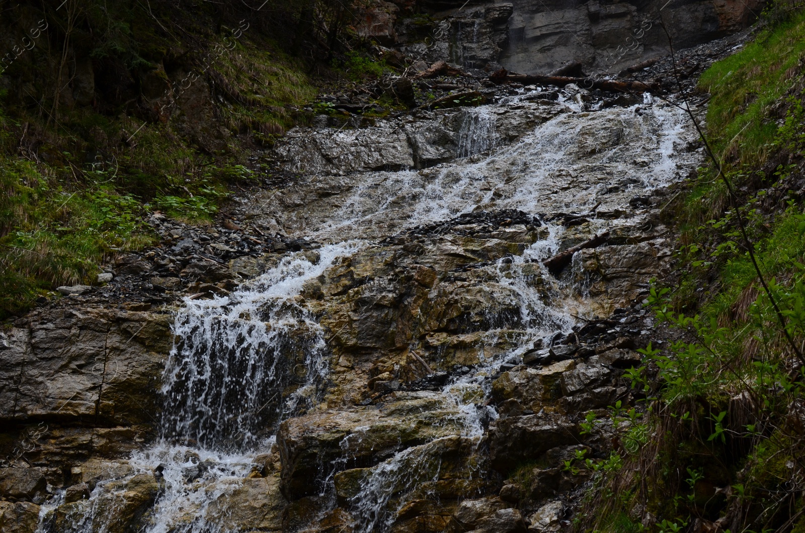 Photo of Picturesque view of beautiful mountain waterfall and rocks outdoors