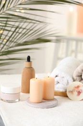 Spa composition. Burning candles and personal care products on soft surface