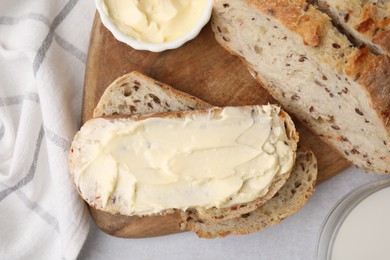 Photo of Tasty bread with butter and milk in glass on table, flat lay