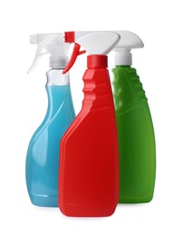 Photo of Spray bottles with detergents on white background. Cleaning supplies