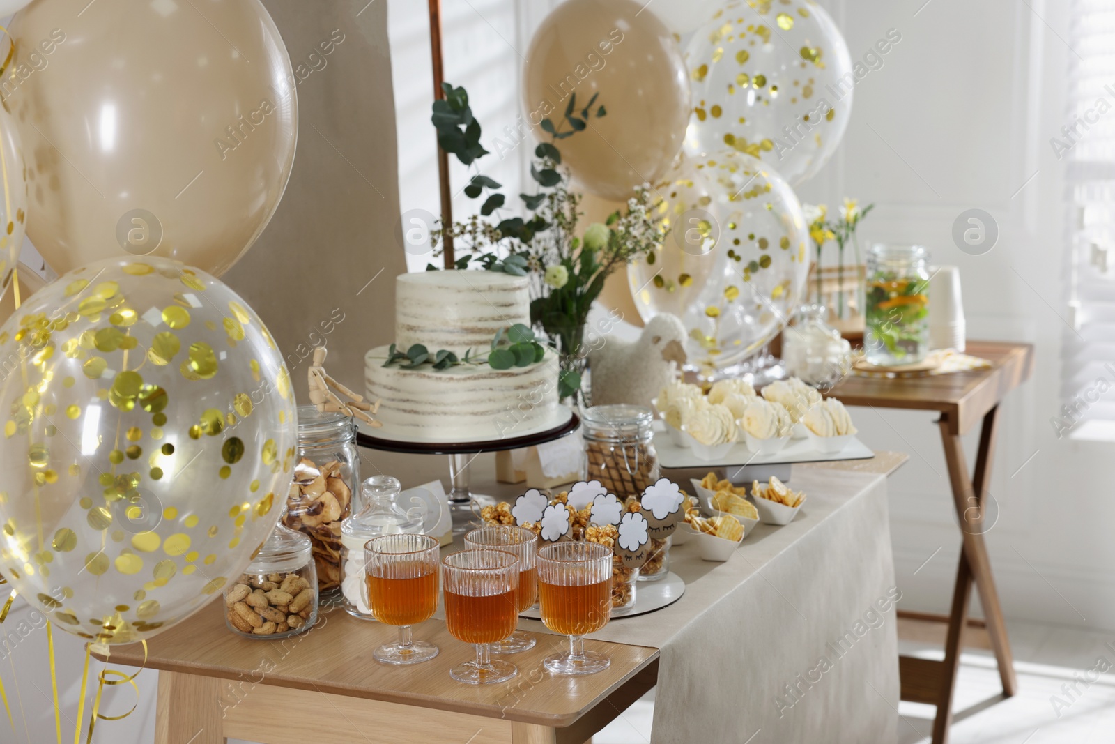 Photo of Beautiful cake and other treats on table in room. Baby shower party