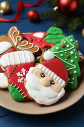 Different tasty Christmas cookies on blue wooden table, closeup
