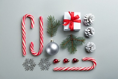 Flat lay composition with candy canes and Christmas decor on grey background
