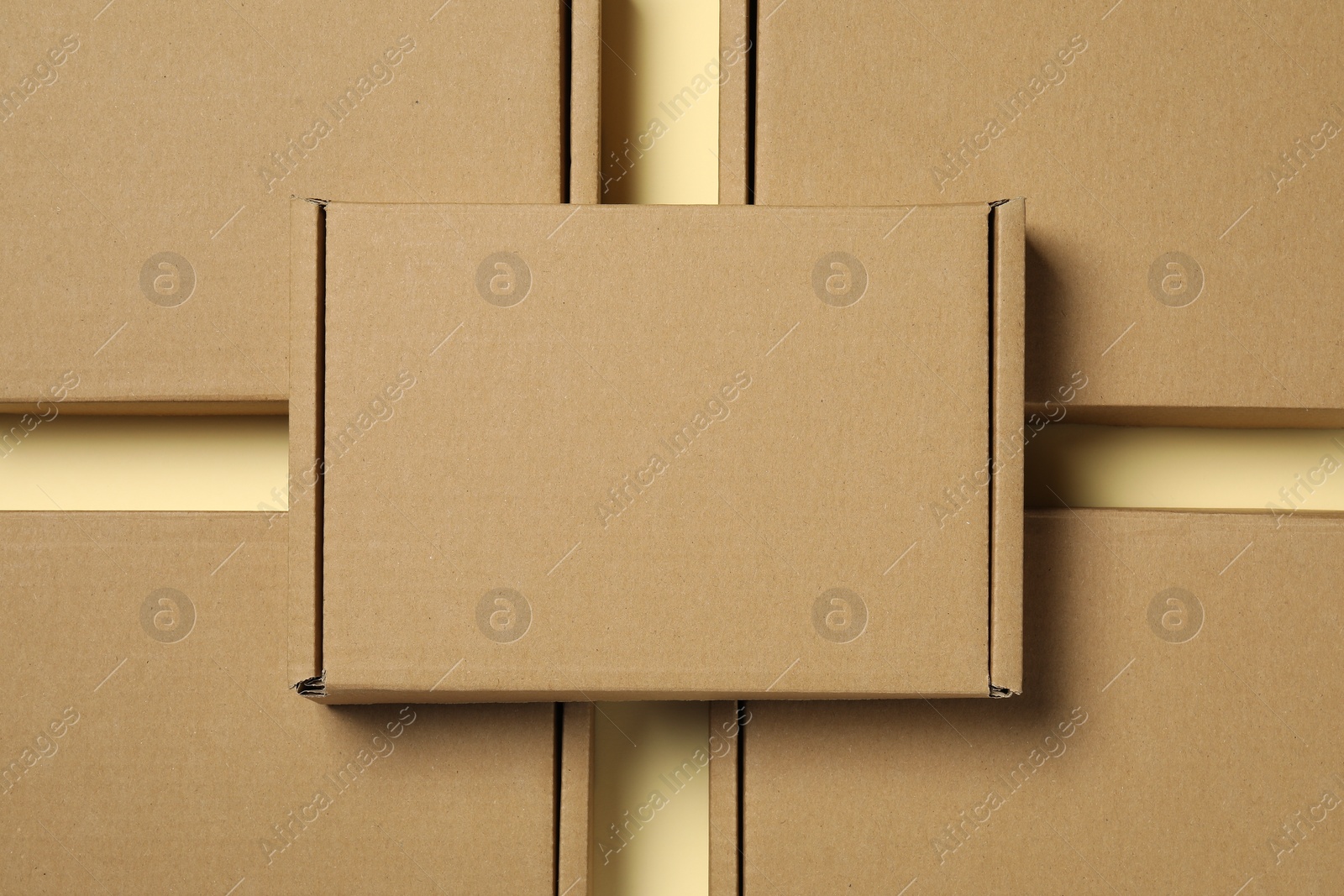 Photo of Many closed cardboard boxes on pale yellow background, flat lay