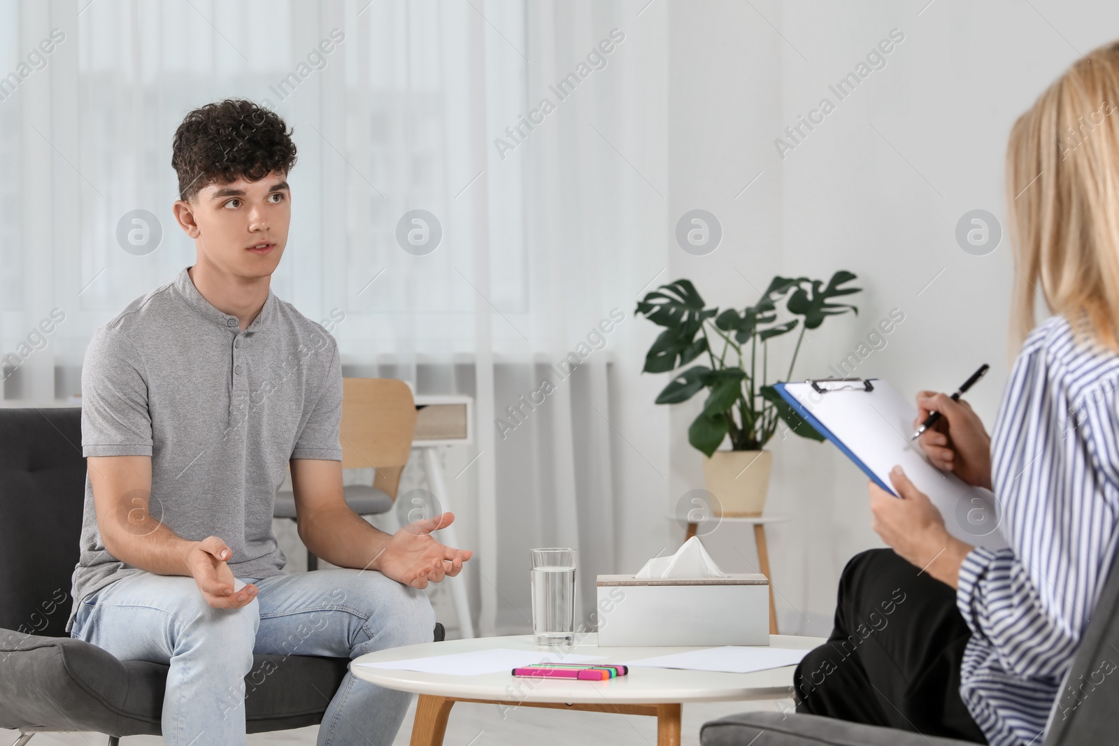 Photo of Psychologist working with teenage boy in office. Teenager problems