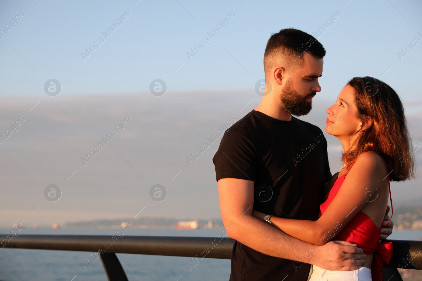 Photo of Happy young couple hugging on sea embankment