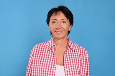 Photo of Portrait of smiling senior woman on light blue background