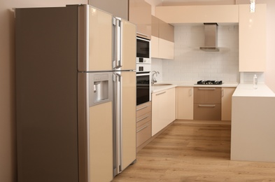 Interior of spacious modern kitchen with refrigerator