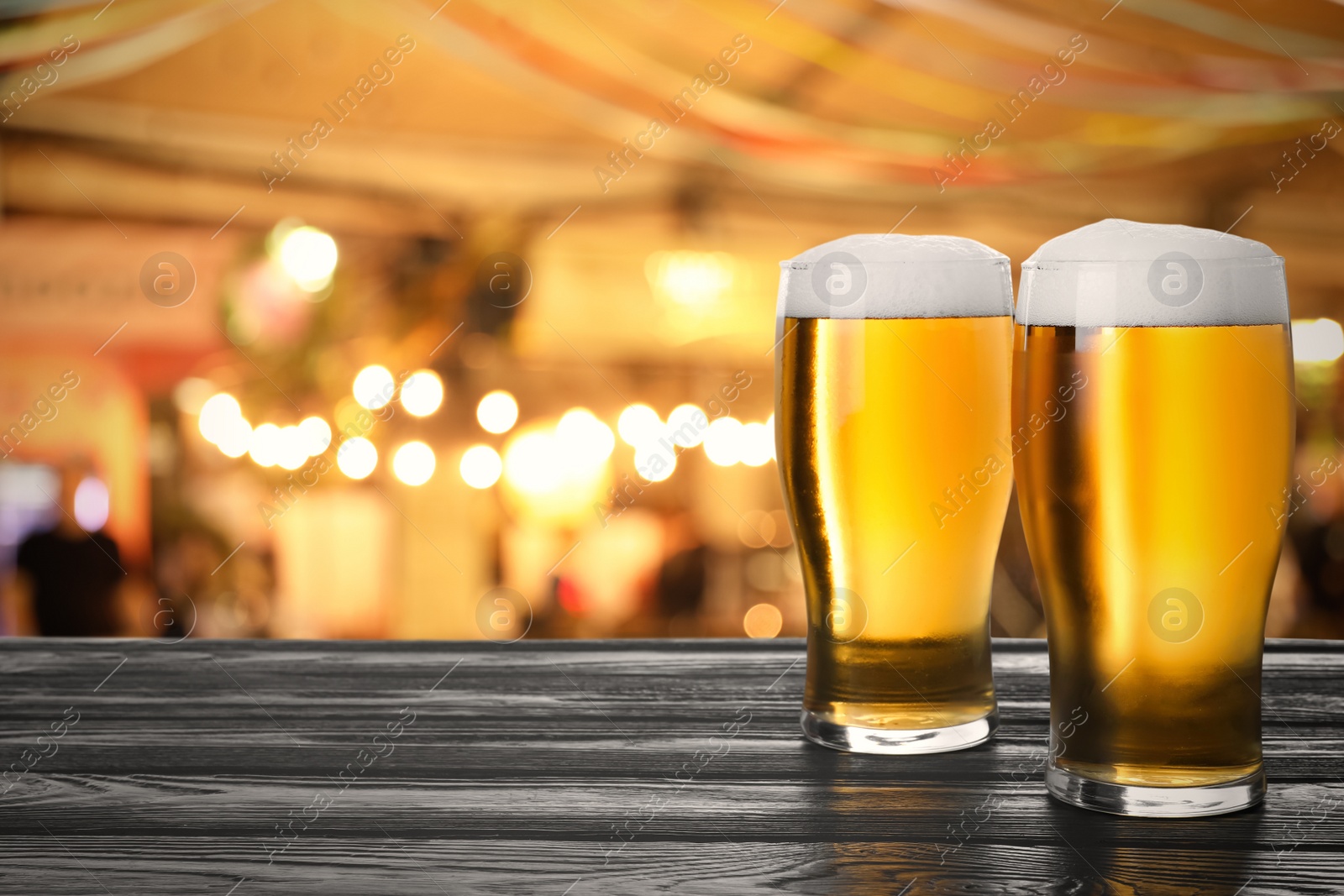 Image of Fresh cold beer on wooden table in pub, space for text 