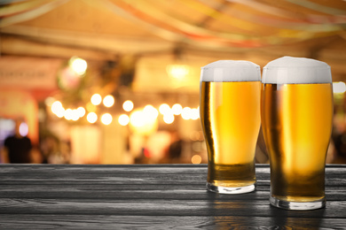 Fresh cold beer on wooden table in pub, space for text 