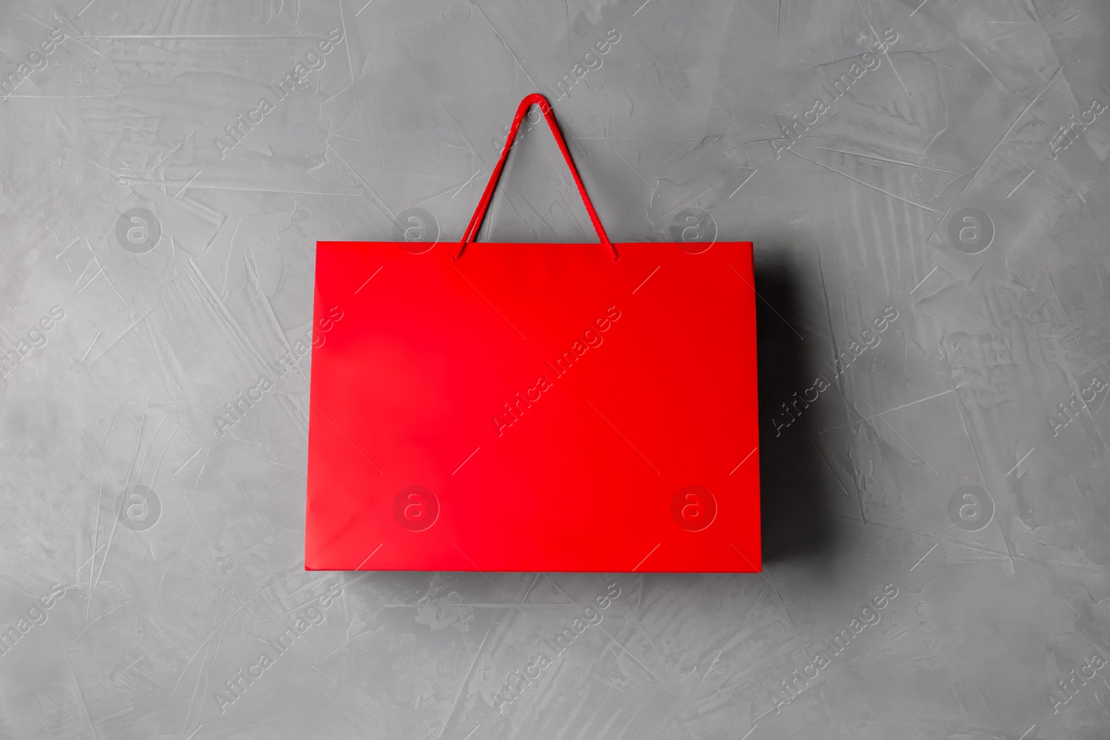 Photo of Paper shopping bag hanging on grey wall