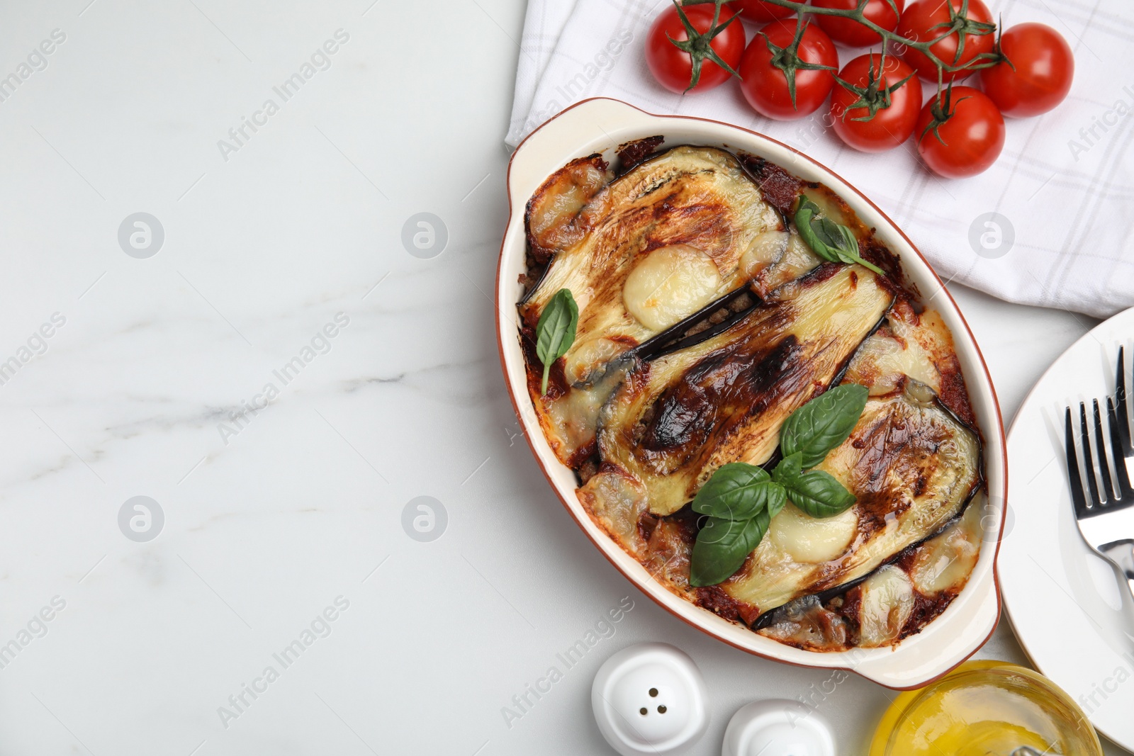 Photo of Delicious eggplant lasagna in baking dish on white marble table, flat lay. Space for text