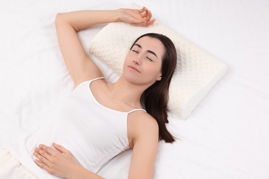 Woman sleeping on orthopedic pillow in bed