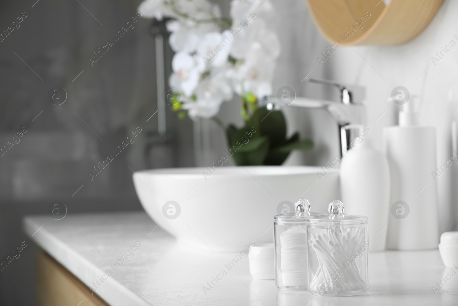 Photo of Containers with cotton swabs and pads on white countertop in bathroom. Space for text