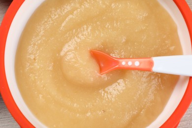 Photo of Healthy baby food. Bowl with delicious apple puree on white wooden table, closeup