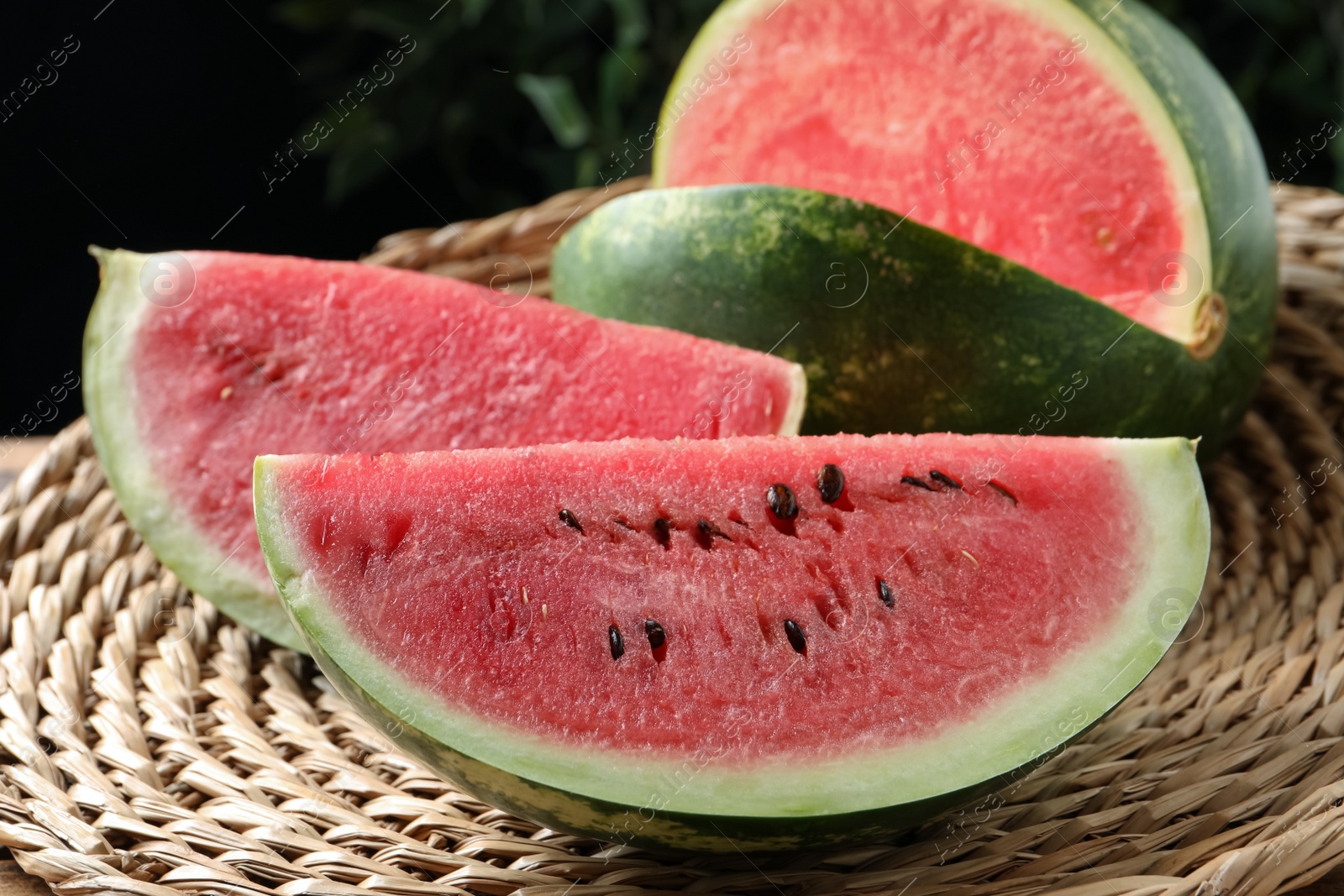 Photo of Delicious fresh watermelon slices on wicker mat, closeup