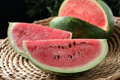 Photo of Delicious fresh watermelon slices on wicker mat, closeup