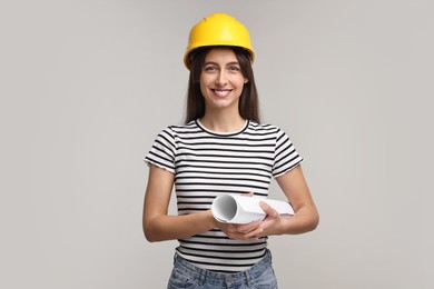 Architect with hard hat and draft on light grey background