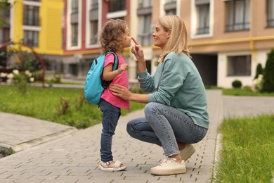 Happy mother and daughter near kindergarten outdoors