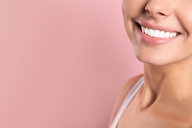 Young woman with healthy teeth on color background, closeup. Space for text