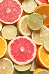 Different cut citrus fruits on beige table, flat lay