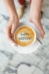 Image of Happy Weekend. Young woman with cup of delicious coffee on blurred background, top view